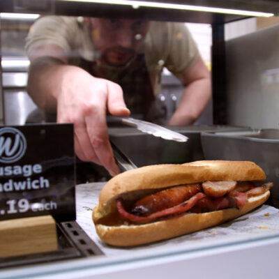 Warner's retailer reaching for a warm sandwich in a Fri-Jado hot food display